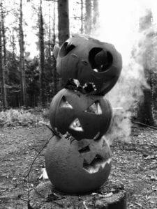 black and white photo of a totem pole made of carved out pumpkins