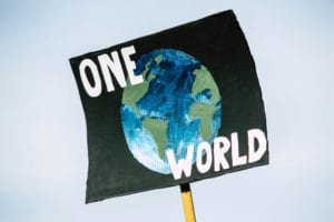 placard-with-the-words-one-world-surrounding-the-picture-of-the-earth.